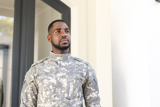 African American soldier in military uniform stands confidently with copy space
