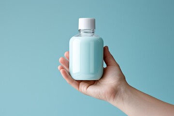 Caucasian Womans Hand Holding Vibrant Blue Elixir Bottle. Minimalist Design with Clean White Lid, Label-Free. Against Serene Blue Background, Evoking Sophistication, Mystery, and Elegance.