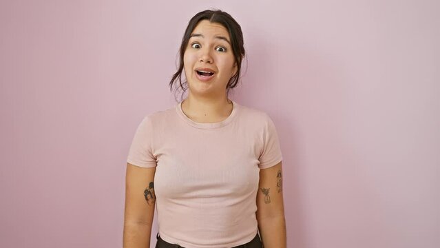 Hilarious young hispanic woman sporting a bloated, cheek-inflated, funny face! puffing cheeks full of air in crazy joy, over isolated pink wall - a breathtaking sight!