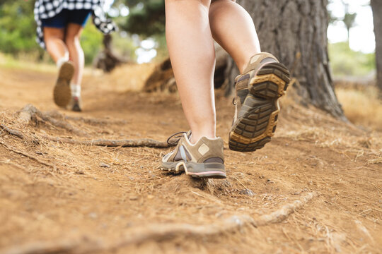 Close-up of hiking boots on a dirt trail, with another hiker ahead on a hike