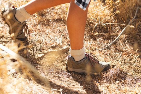 Close-up of a person's legs wearing hiking boots on a trail during a hike
