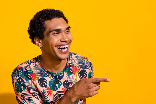 Photo of young laughing guy wearing t shirt free time at comic stand up show direct finger empty space isolated on yellow color background