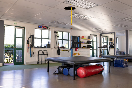 A spacious room features gym equipment like mats and weights, with a clear view outdoors