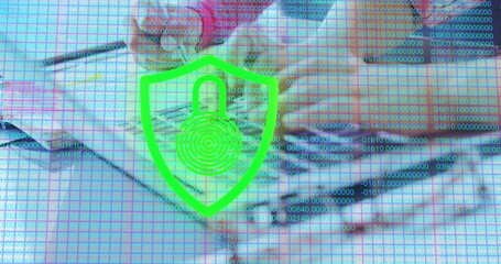 Image of digital online security padlock icon over schoolchildren using laptop computer at school