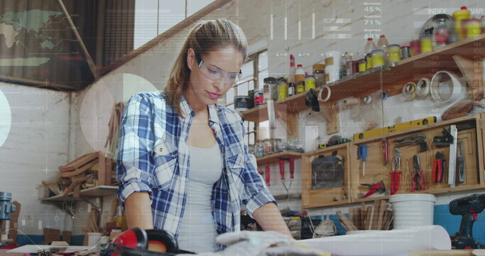 Image of data processing over caucasian female carpenter working in workshop