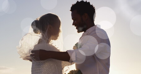 Image of dots over happy african american newly married couple on beach