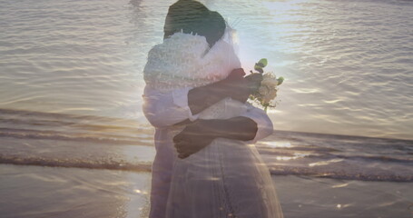 Image of sea over married african american couple at beach