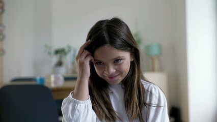 Obraz premium One pensive little girl having a breakthrough idea. Close-up face of a thoughtful child experiencing an eureka moment, indoors at home