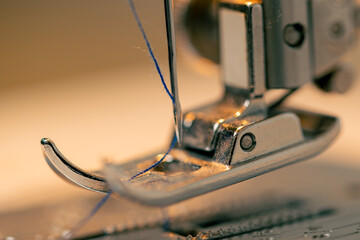 close-up in a sewing workshop thread is inserted into a needle on a machine