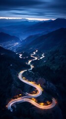 Aerial panoramic view of curvy mountain road with trailing lights at night
