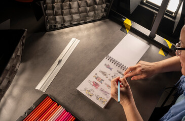 dessin au crayon sur un carnet à spirale avec des lumières pendant un tournage vidéo