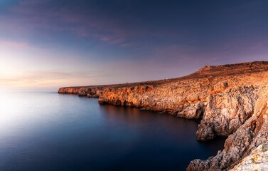 Fototapeta na wymiar cliffs and rugged shorelina at Pont d'en Gil in northeastern Menorca near Ciutadella just after sunset