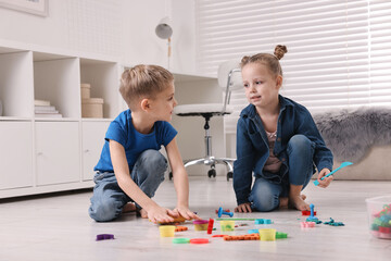 Cute little children playing on warm floor at home. Heating system