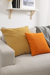 Soft pillows and blanket on sofa indoors