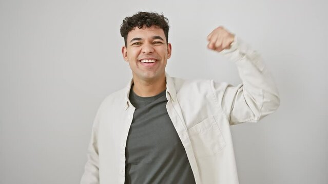 Unbelievable success! excited young arab man in casual clothes, eyes shut, arms high, celebrating his joyful triumph isolated on a white background