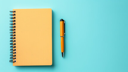 Top view of notepad with pen lying on blue background