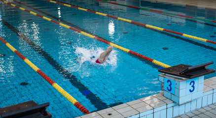 Sportswoman, a professional swimmer at the start of the swimming race, beginning drive from the...