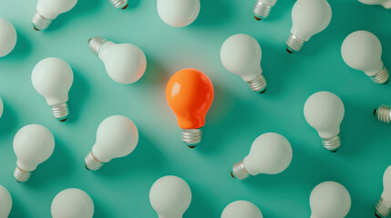 An orange lightbulb glowing among a group of white lightbulbs on a teal background, representing a unique idea or solution.