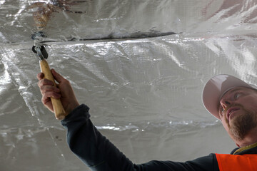 the construction worker uses aluminum tape and they had a roller for vapor barrier joints on the...