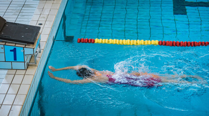 Professional sportswoman, a swimmer during freestyle swimming training, ultimate sports drills in...