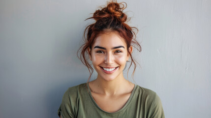 joyful young woman with a big smile, against a neutral background.