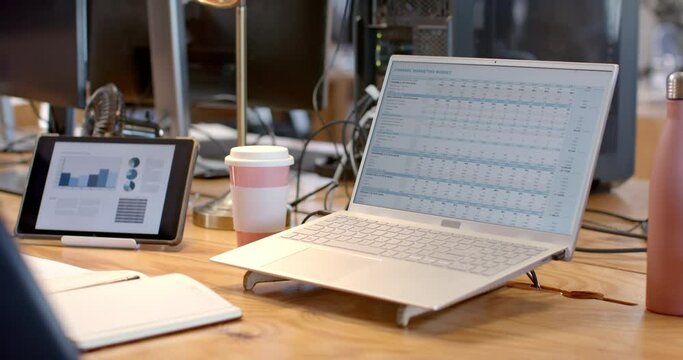 A Laptop Displays A Detailed Business Budget Spreadsheet In An Office Setting