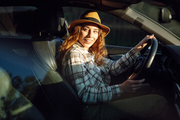 Beautiful young woman driving her car. Woman traveler. Summer vacation and adventure.