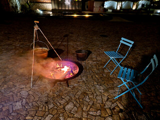 night grilling and roasting on an open fire. the metal bowl is filled with wood and is portable....