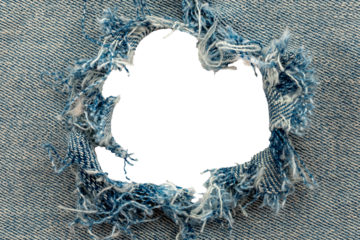 Hole in denim on a white background. Ripped jeans