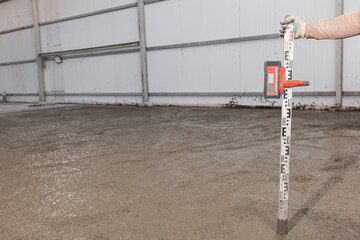 Process leveling floor after pouring cement. Construction site Worker man use laser level for...