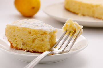 concept of delicious baking, a piece of lemon cake on a fork, close-up