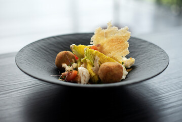 Gourmet caesar salad on black wooden plate