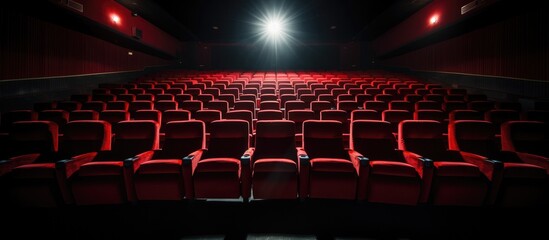 An empty theater with rows of red seats, devoid of any audience or performance. The theater appears silent and unused, with the seats waiting for occupants that never arrived.