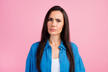 Photo of puzzled minded intelligent nice girl with straight hairdo dressed blue shirt look at camera isolated on pink color background