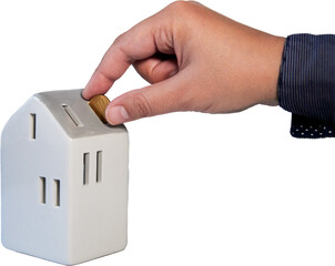 Hands putting coins into a model house as a conceptual image of property mortgage, rent, loan or home finance