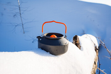 An iron kettle on a hike stands in the snow, metal utensils for boiling water in the forest, dishes...