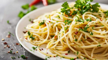 Classic Spaghetti Aglio e Olio. Al Dente Pasta Tossed with Garlic, Olive Oil, and Parsley. Spaghetti Aglio e Olio Garnished with Fresh Herbs and Red Pepper Flakes. A Traditional Italian Favorite