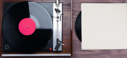 vinyl record player, on a wooden table, there is a place for an inscription on the cardboard...