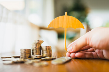 Businessman or model umbrella on a pile of money placed on the table is a figure with concepts of...