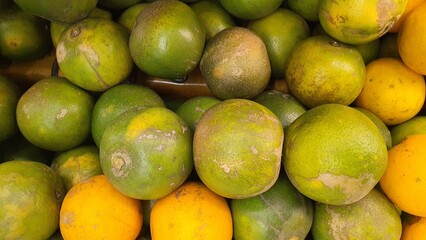 Close up pile of tasty fresh oranges sold at the market as a background.