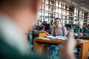 Female college student raising hand in class