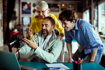 Diverse team reviewing photos on a camera in a creative workspace