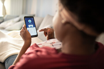 African American woman checking bank account on smartphone app