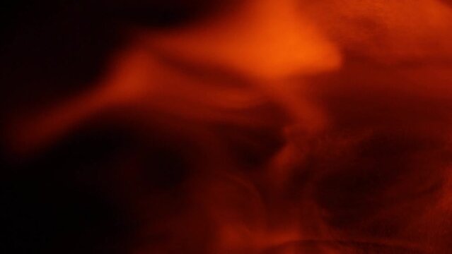 4K Warm Ember Smoke Abstract Swirling Moving Background. Fiery smokey wavy movement on black.