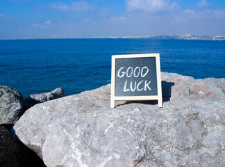 Good luck symbol. Good luck black chalk blackboard. Beautiful sea background. Business and Good luck concept. Copy space.