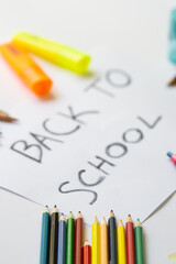 school accessories on a white background and white paper in the middle with 