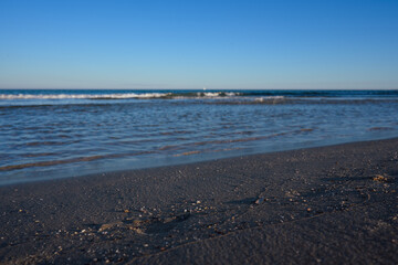 Waves Roll Onto Sandy Beach