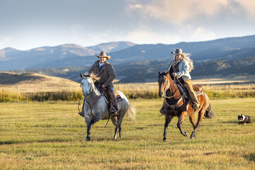 cowboy and Cowgirl couple racing across pasture horseback