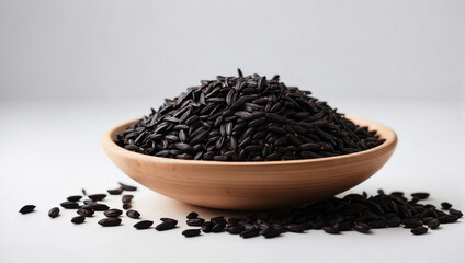 An elegant image of black rice neatly poured into a wooden bowl, with a few grains scattered around