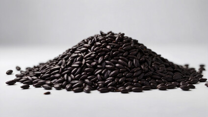 An image of a pile of black rice neatly scattered against a light background, showing off its natural shine and texture